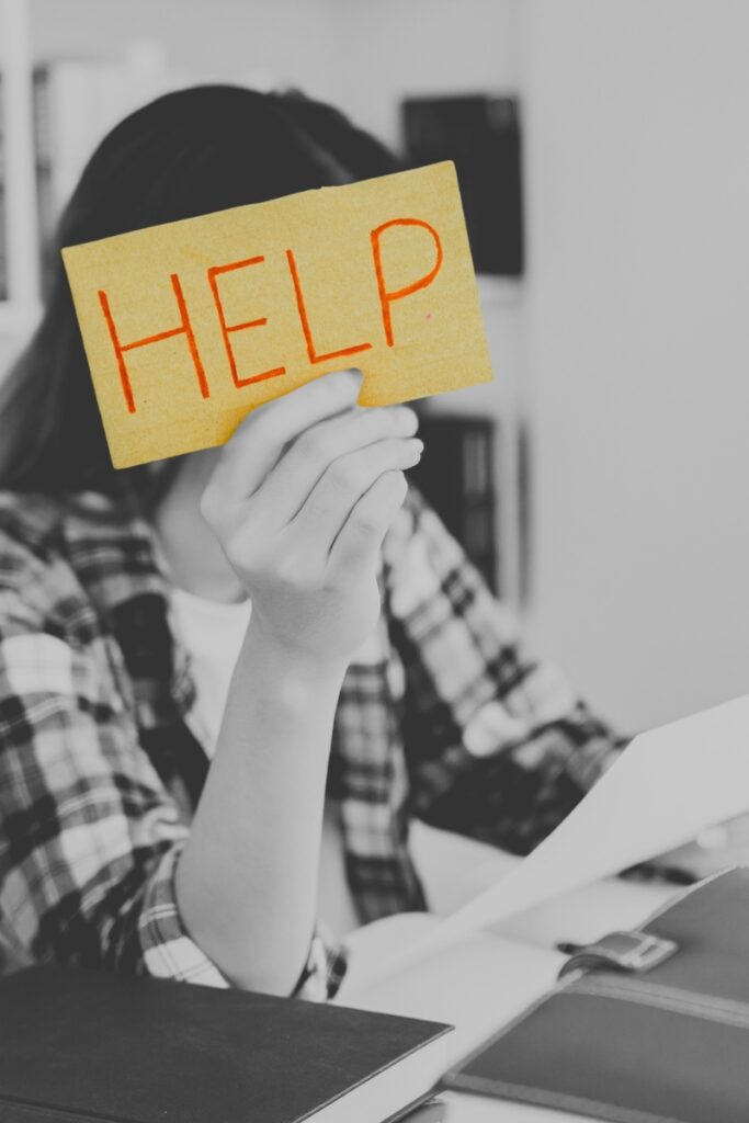 Change Management - Unsicherheit im Unternehmenswandel: Mitarbeiterin mit HELP Schild